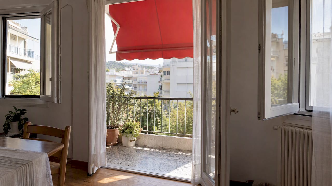 Μπαλκόνι με τέντα και ανοιχτά παράθυρα
